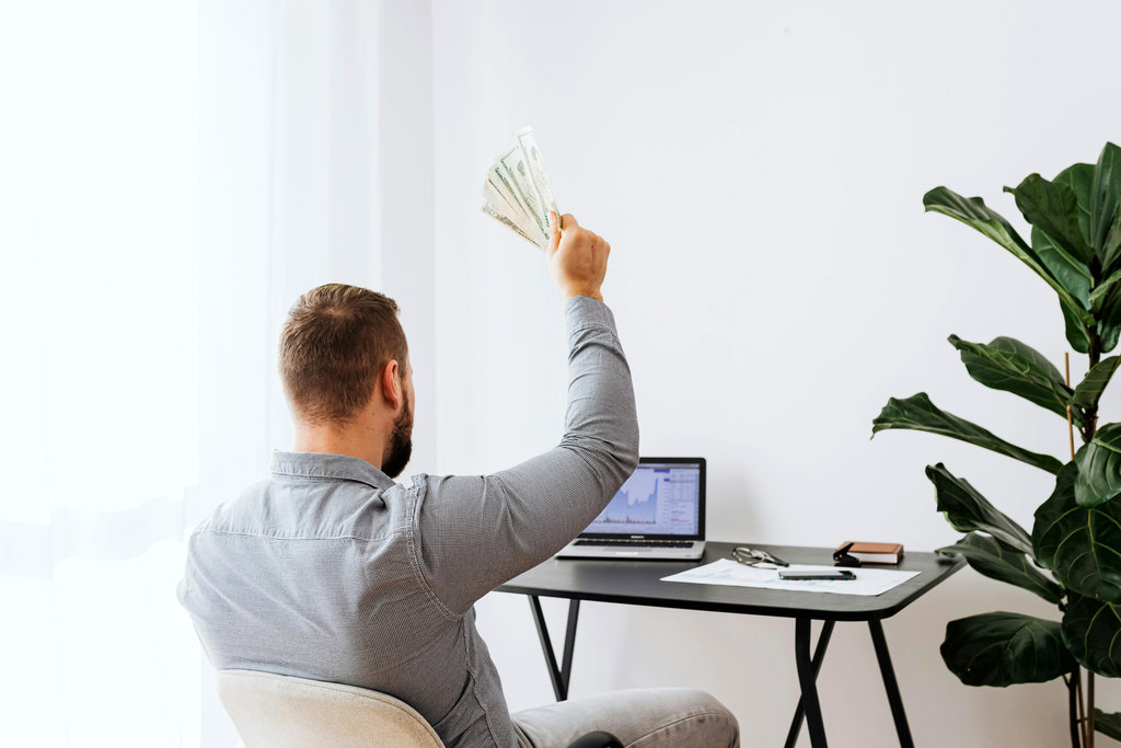 Homme qui brandit une liasse de billets