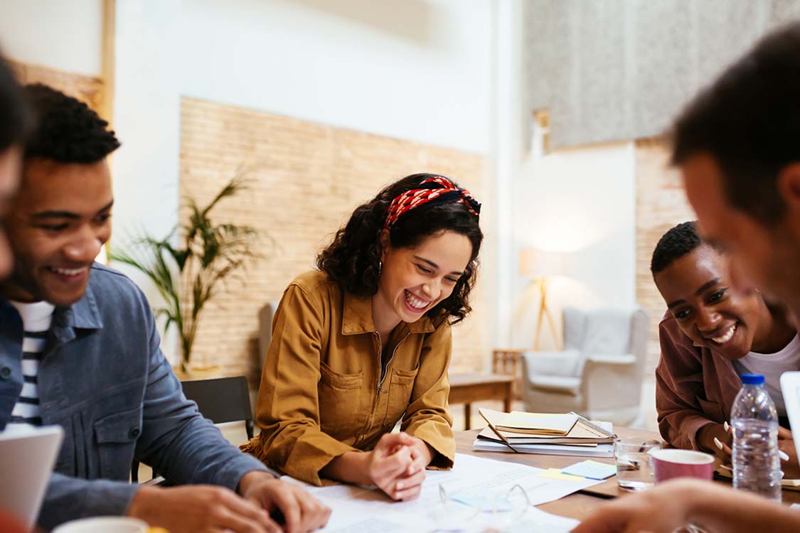personnes travaillant ensemble en souriant